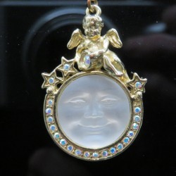 Kirks Folly pendant or charm with a moon face and cherub